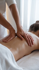 A massage therapist performing a back massage on a woman in a spa setting with soft lighting and candles, symbolizing relaxation, wellness, and therapeutic care.