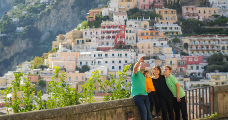Family with kids making selfies in front of Positano on Amalfi Coast in Italy