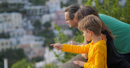Young family admiring panorama of Positano on Amalfi Coast in Italy