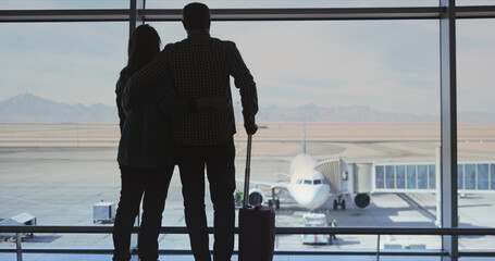 Lovers couple wait the boarding on their flight in the airport