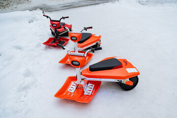 Three powerful snowmobiles are perfectly lined up in the thick, fluffy snow, ready for thrilling...