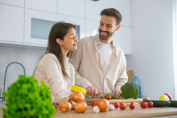 A couple prepares a healthy meal with fresh ingredients, emphasizing joy and connection in their warm and inviting kitchen.