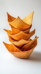 Fototapeta premium Five golden tortilla bowls showcase their unique shapes and crispy textures on a light backdrop