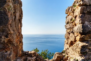 Picturesque View of the Calm Ocean Through Rocky Ruins by the Coast..