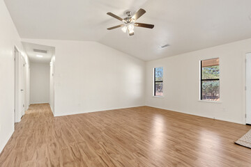 Spacious living room with wooden flooring and sliding doors leading to a bright outdoor area