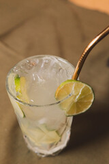 Overhead view of a caipirinha cocktail served in a glass on a table.
