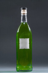 bottle with homemade alcohol tincture or liquor, mockup with empty label, tarragon and peppermint