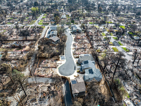 Aerial view of the Eaton Fire destruction in Altadena, California, showing entire neighborhoods devastated by wildfire alongside surviving homes and streets