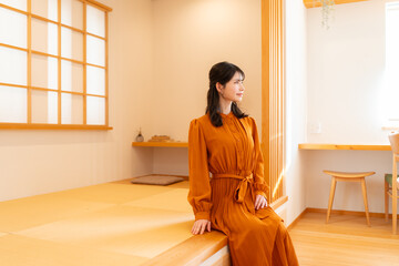 畳の小上がりに腰掛ける若い女性
