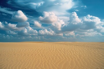 Naklejka premium Expansive desert landscape under a bright blue sky with majestic mountains and soft clouds in a distant horizon during daytime