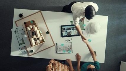 Top view of architect engineer working together and shaking hand cooperative team while making contract and dealing about budget. Aerial view of manager standing and talking about plan. Alimentation.