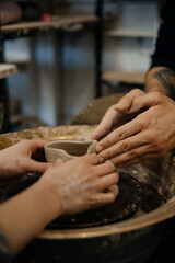 hands of a potter, making heart from glay