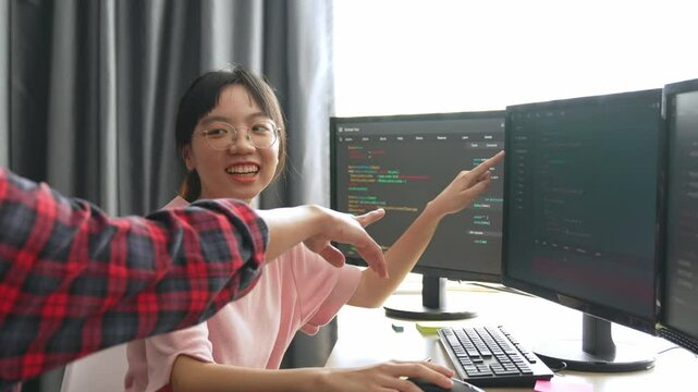 Slow motion back end software developer engineer for computer programming working together on debugging writing computing code, solving complex algorithms display on monitor in office. Burgeoning