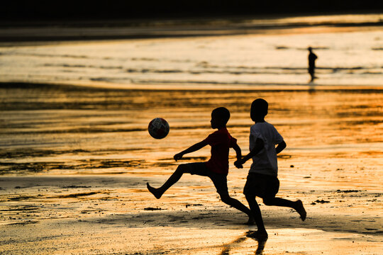 Ni&ntilde;os jugando futbol al atardecer