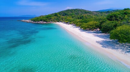 Obraz premium Aerial view of tropical beach with clear turquoise water and lush green trees under blue sky