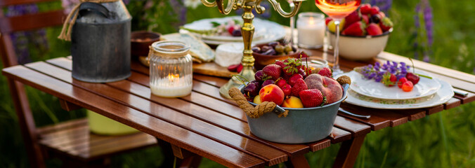 Banner. Perfect surprise date for loving couple, private wedding, romantic marriage proposal. Summer, sunset, golden hour. Beautiful elegant outdoor arrangement in meadow with purple blue lupins