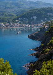 Fototapeta premium Scenic view of Port de Soller Bay with numerous yachts, boats anchored in turquoise waters. Picturesque Mediterranean coastal scene surrounded mountains, charming waterfront buildings