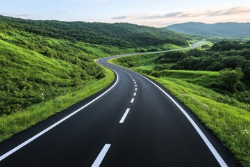 Winding road through lush green hills during sunrise in a tranquil rural setting