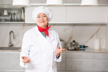 Portrait of a positive and confident mature female chef posing in a home kitchen