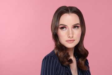 Fototapeta premium Portrait of beautiful young woman with stylish makeup and gorgeous hair on pink background. Space for text