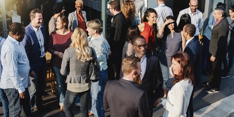 A diverse group of people socializing at an outdoor event. Men and women of various ethnicities are engaged in conversation, enjoying the gathering. Diverse people mingle in social event outdoors.