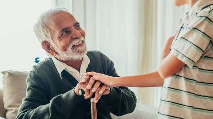 Fototapeta premium Elderly Indian man talking with a young boy. Grandfather talking to grandson. Grandson visiting old grandfather in retirement home. Retirement home visiting.