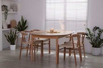 Stylish wooden table with chairs and decor indoors. Interior design