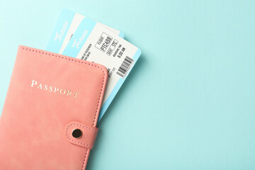 Passport with tickets on light blue background, top view. Space for text