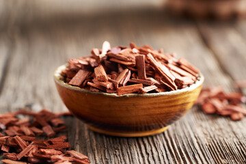 Pieces of red sandalwood in a wooden bowl