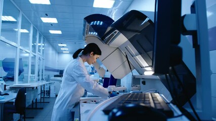 A scientist works with high-tech equipment in a modern laboratory, analyzing biological material and conducting experiments. Concept research of biological samples using cutting-edge technology.
