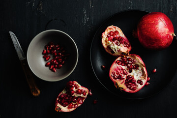 Fresh pomegranates on a dark background.