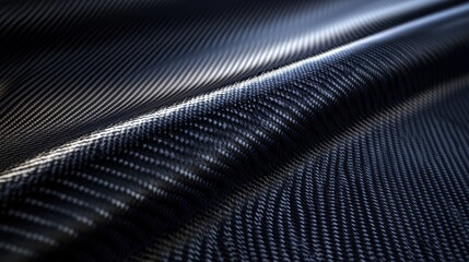 Close-up of shiny black carbon fiber material with textured surface and light reflections