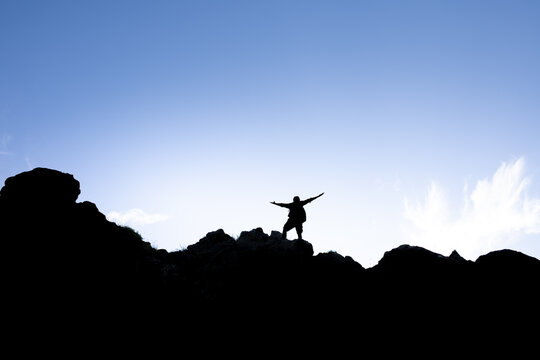 Man climbs to the summit feeling fearless, courageous, determined, empowered 