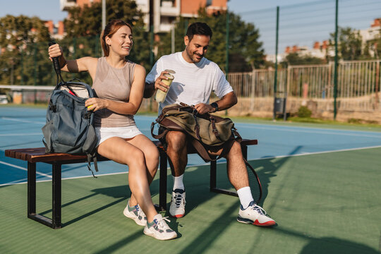 Young couple playing tennis outdoors enjoying a fun summer game