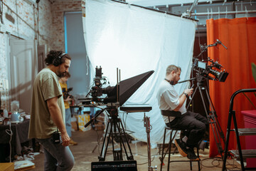 Director of photography with a camera in his hands on the set. Professional videographer at work on...