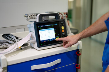 icu nurse's hand with defibrillator