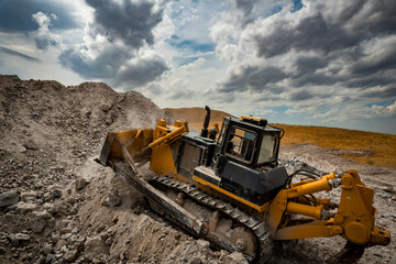Obraz premium Bulldozer is doing its job at gypsum mining quarry
