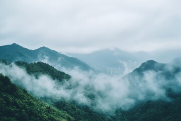 Lush green mountains covered in mist with a distant view of wind turbines, creating a serene and eco-friendly landscape