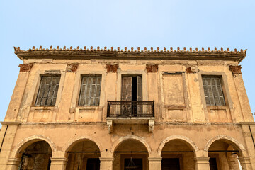 abandoned building with balcony and peeling window shutters in Koroni, Peloponnese, Greece