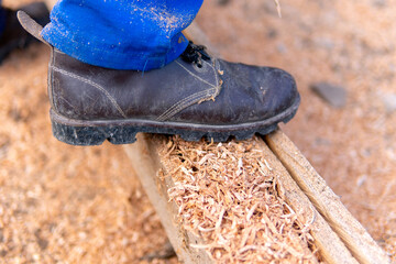 Man's boot on a sawn log during farm work in Colombia