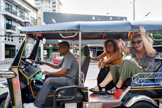 Thai tuk tuk driver with female tourists in Chiang Rai city
