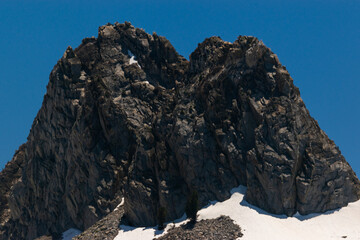Rocky mountains with pine trees under a bright blue sky