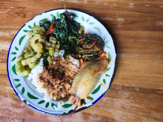 Indonesian meal of rice, squid, and sauteed vegetables.