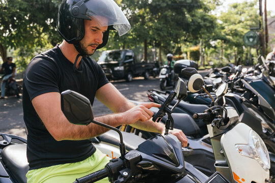 Man using smartphone on motobike in Bali