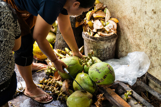 Preparing Fresh Coconuts for Consumption in a Local Market