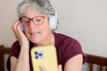 Senior woman enjoying a video call with headphones on
