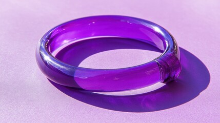Chic acrylic bracelet in translucent purple tones, resting stylishly on a bold purple backdrop