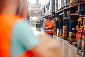Warehouse workers managing inventory and logistics with digital tablet