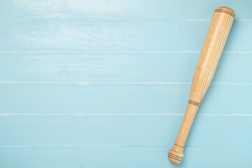 Wooden baseball bat on wooden background, top view