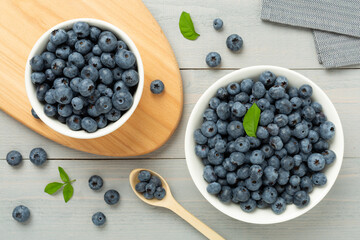 Bowl with fresh bright blueberries on wooden background,top view